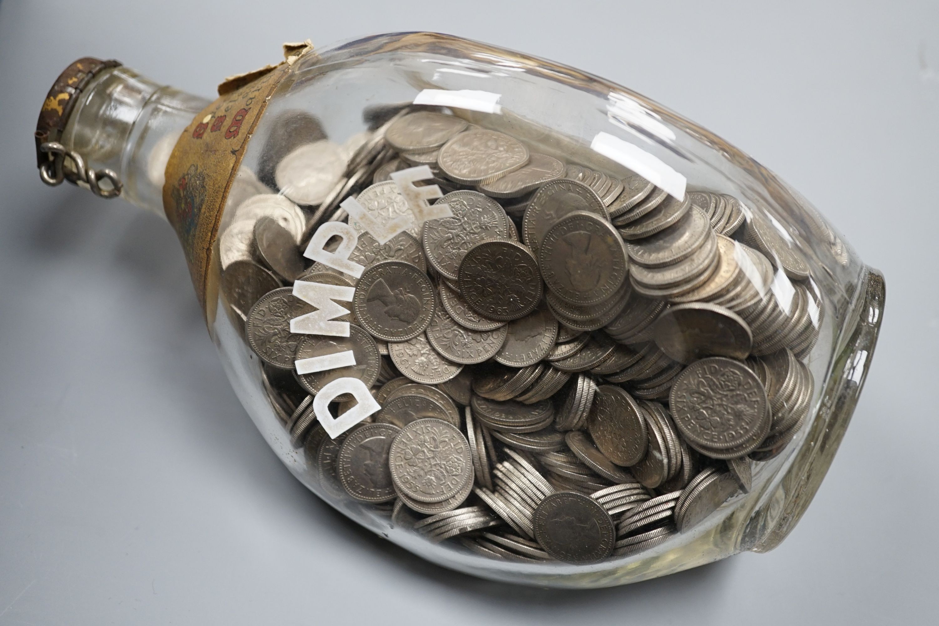 A large bag of UK pennies, coins and a bottle of sixpences